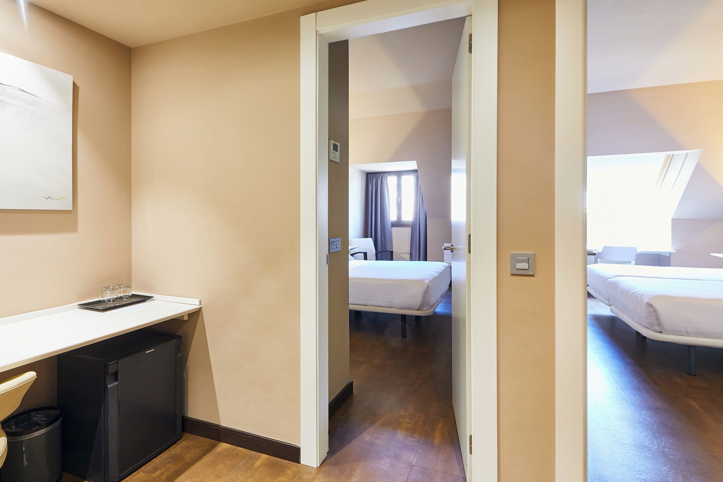 Ein Hotelzimmer mit Schreibtisch, Bett und Fenster.