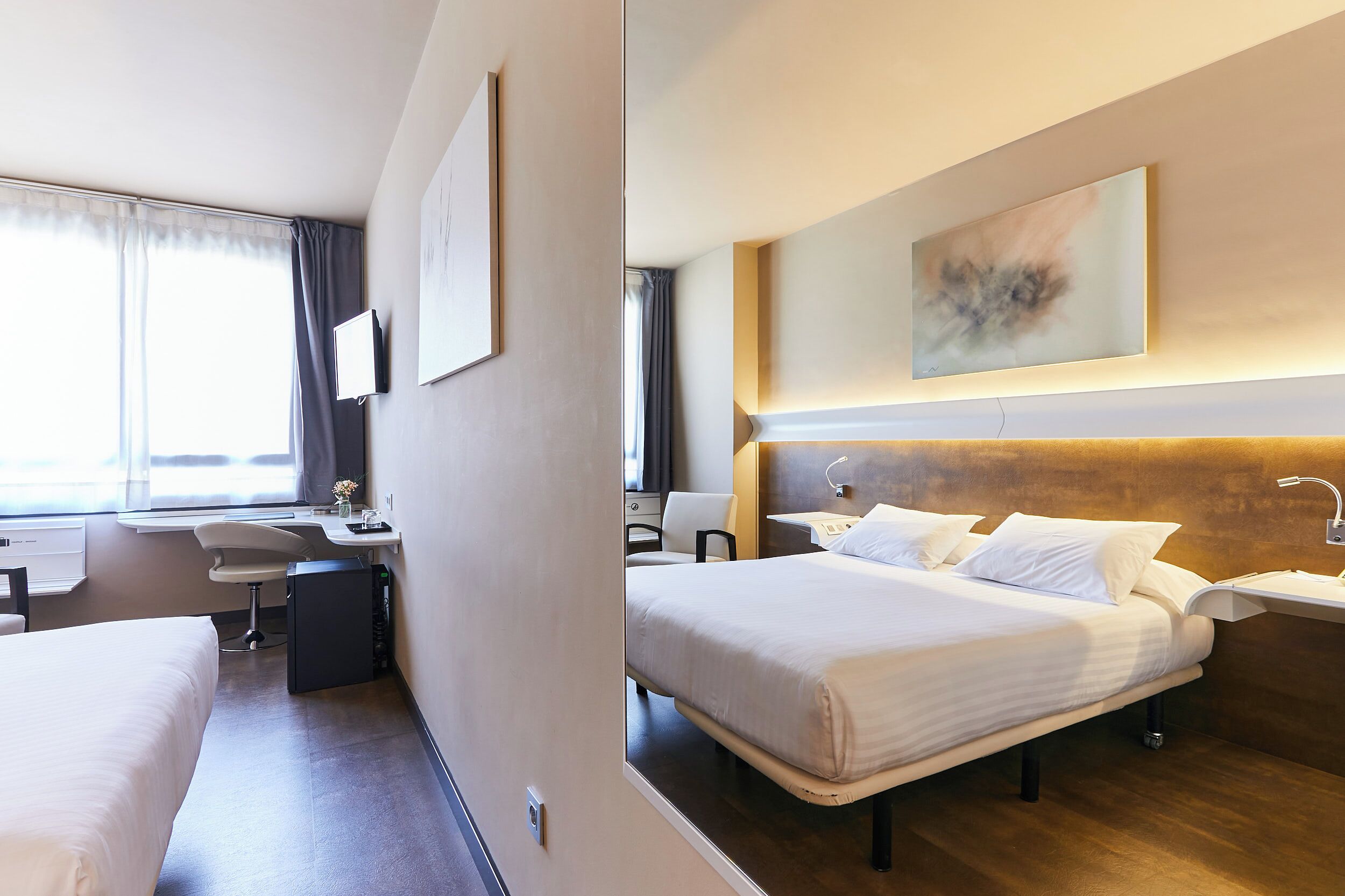 Une chambre d’hôtel moderne avec un grand lit, une table de chevet et un bureau avec une chaise.
