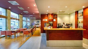 Un café moderno con mobiliario de madera, una zona de bar y vistas a la calle.