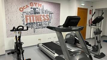 A gym with a treadmill, elliptical, and stationary bike.