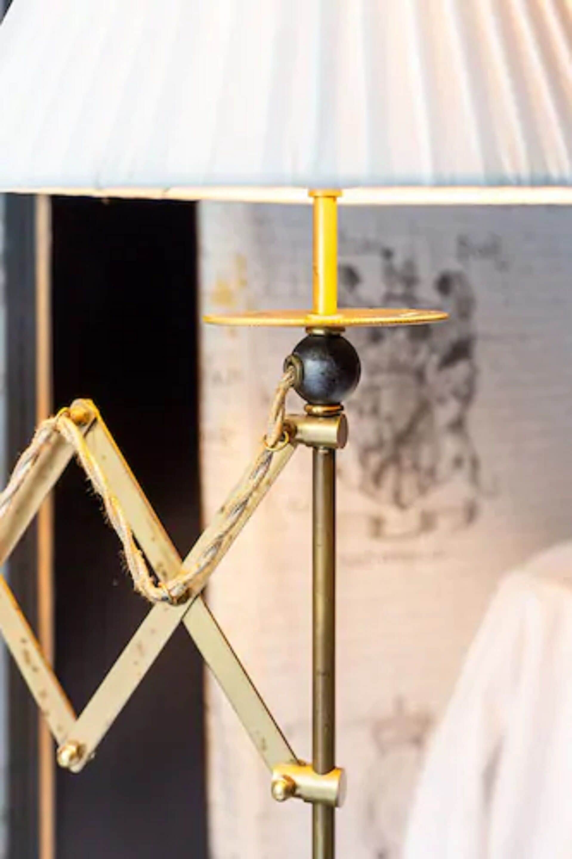En lampa i vintage-stil med en unik, geometrisk design, en metallisk yta och en guldfärgad fot.
