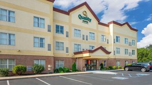 A hotel with a sign reading "Quality Suites by Choice Hotel". - Quality Suites (Indianapolis)