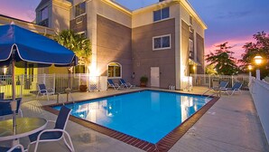A modern hotel with a swimming pool, outdoor seating, and a sunset view. - Best Western Slidell Hotel (Slidell)