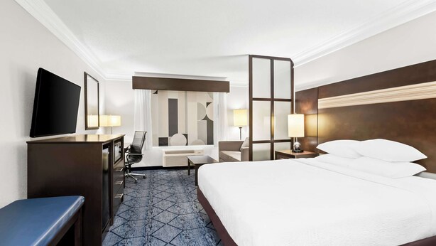 A hotel room with a bed, desk, chair, and a television. - Best Western Slidell Hotel (Slidell)