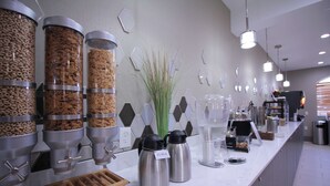 A buffet area with multiple food dispensers, including cereal and granola options, and a coffee station with two stainless steel coffee makers. - Best Western Slidell Hotel (Slidell)