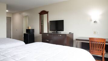 A hotel room with a bed, a desk, a television, and a mirror.