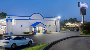 Un hôtel Travelodge à la façade bleue et blanche, doté d’un parking et donnant sur la rue.