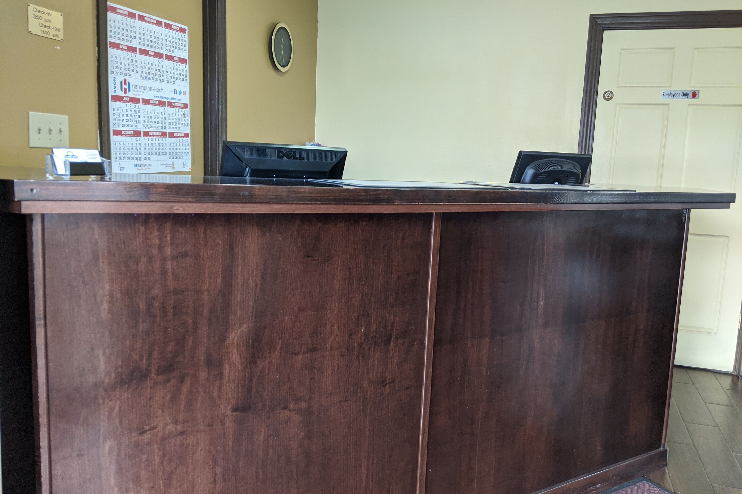 Una recepció amb un ordinador, un calendari i una porta amb la indicació 'Només personal'.