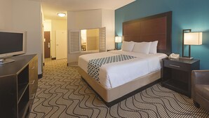 A hotel room with a large bed, bedside lamps, a TV, and a desk with a phone. - Spark by Hilton Central Point Medford (Central Point)