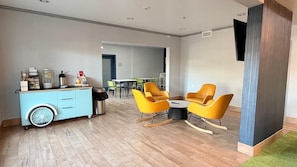 A modern interior with a blue cart, yellow chairs, and a herringbone floor. - Spark by Hilton Central Point Medford (Central Point)