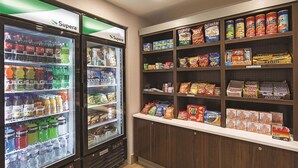 A vending machine stocked with beverages and snacks, including Coca-Cola, Pepsi, and Gatorade. - Spark by Hilton Central Point Medford (Central Point)