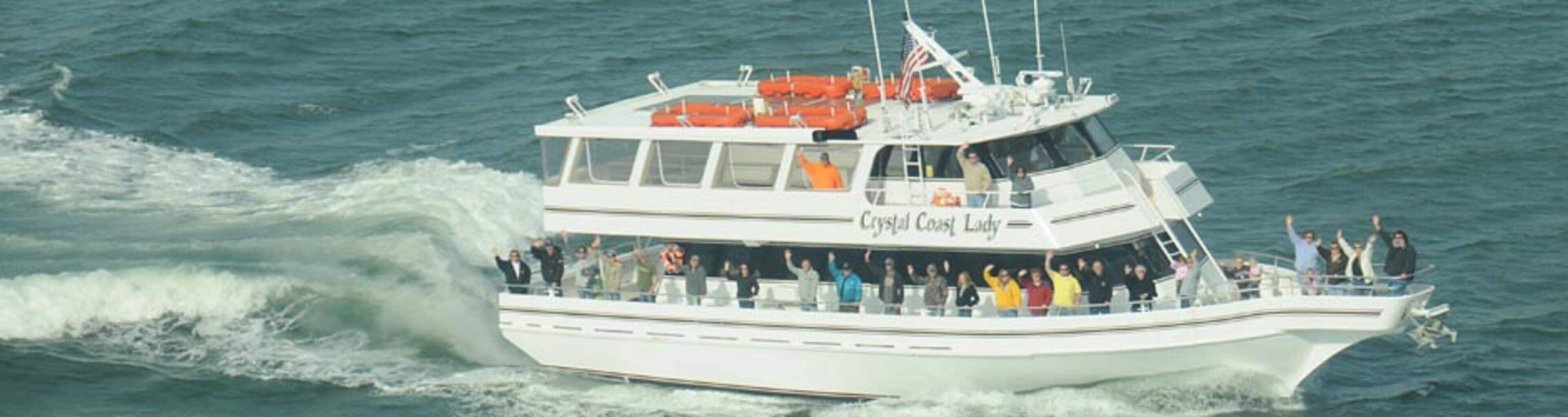 Un vaixell amb diverses cobertes i passatgers, anomenat 'Crystal Coast Lady', navegant a l'aigua.