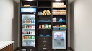 A self-service beverage and snack vending area with multiple drink dispensers and snack bins.
