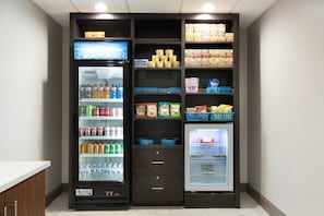 A self-service beverage and snack vending area with multiple drink dispensers and snack bins.