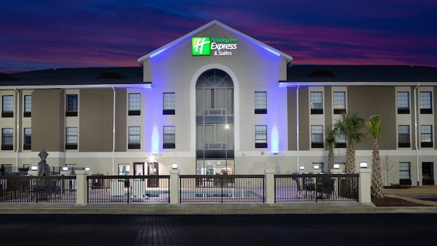A Holiday Inn Express & Suites building with a prominent entrance, a covered outdoor seating area, and a fenced courtyard. - Holiday Inn Express Hotel & Suites Morehead Cty by IHG (Morehead City)