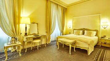A hotel room with a large bed, a bedside table, a mirror, a desk, and a chair.