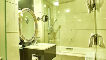 A bathroom with a glass-enclosed shower, a vanity with a mirror, and a towel rack.