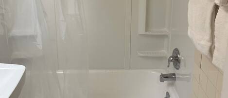 A bathroom with a bathtub, a shower, and a toilet.