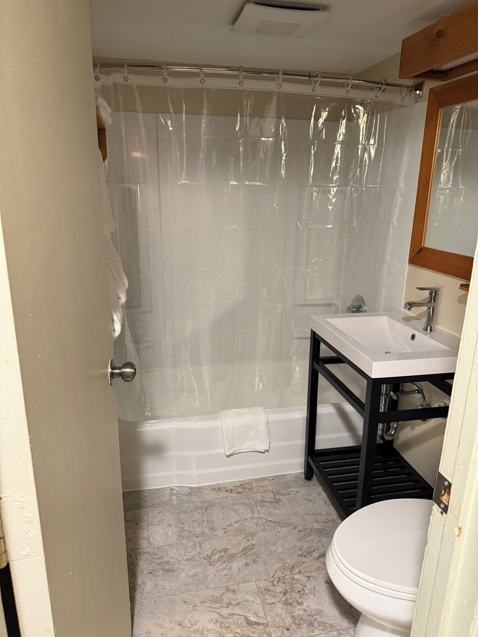 Een badkamer met een bad, een wit wastafel en een toilet.