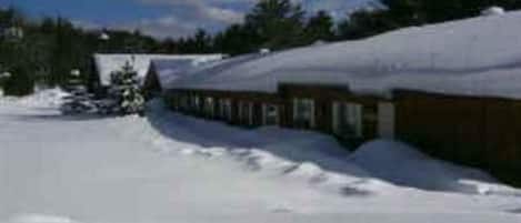 A building with a snow-covered roof, surrounded by a snowy landscape.