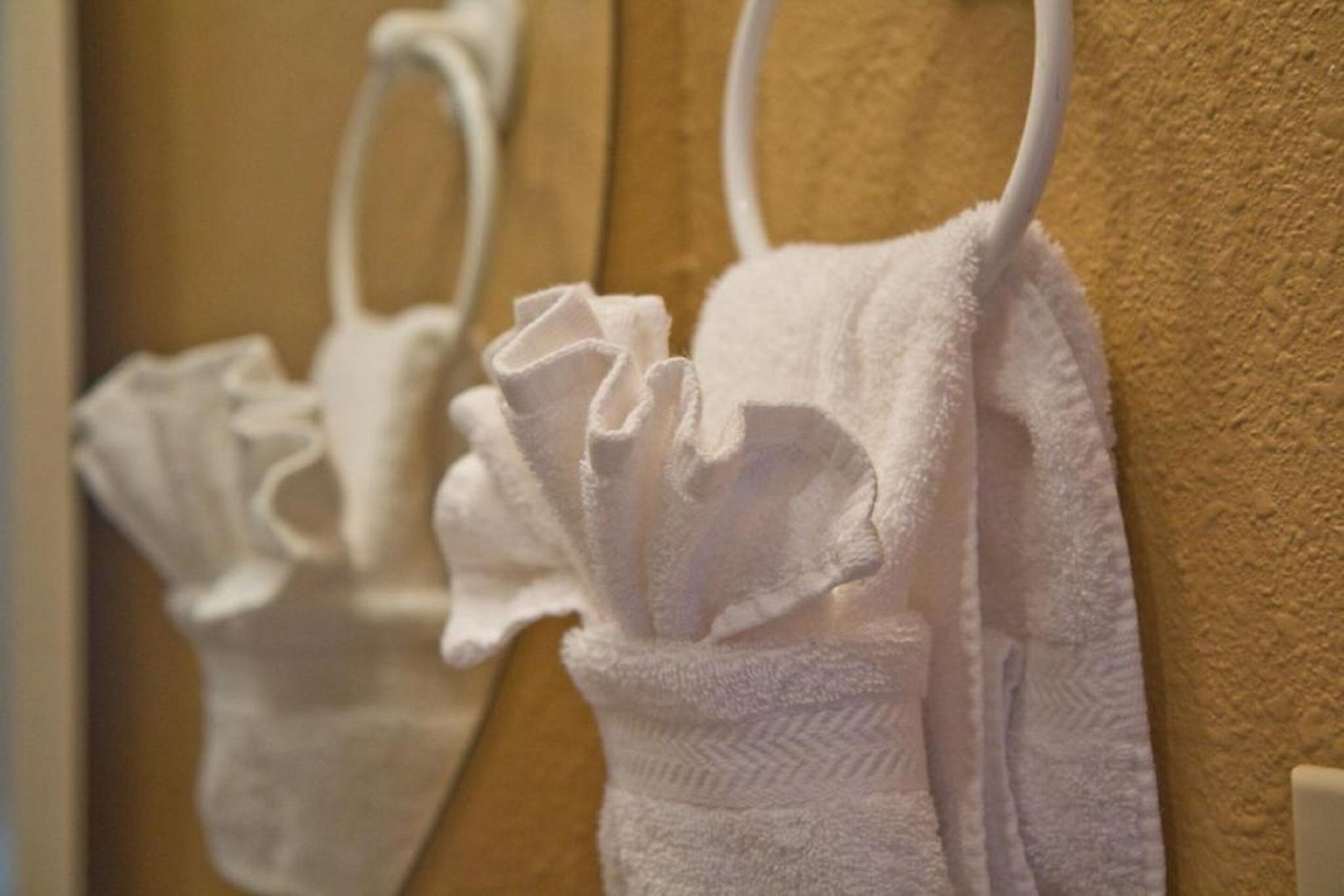 A bathroom with white towels hanging on a rack.