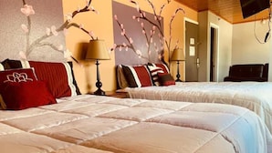 A hotel room with two beds, a television, a lamp, and a wall with floral artwork. - Anchorage Downtown Hotel (Anchorage)