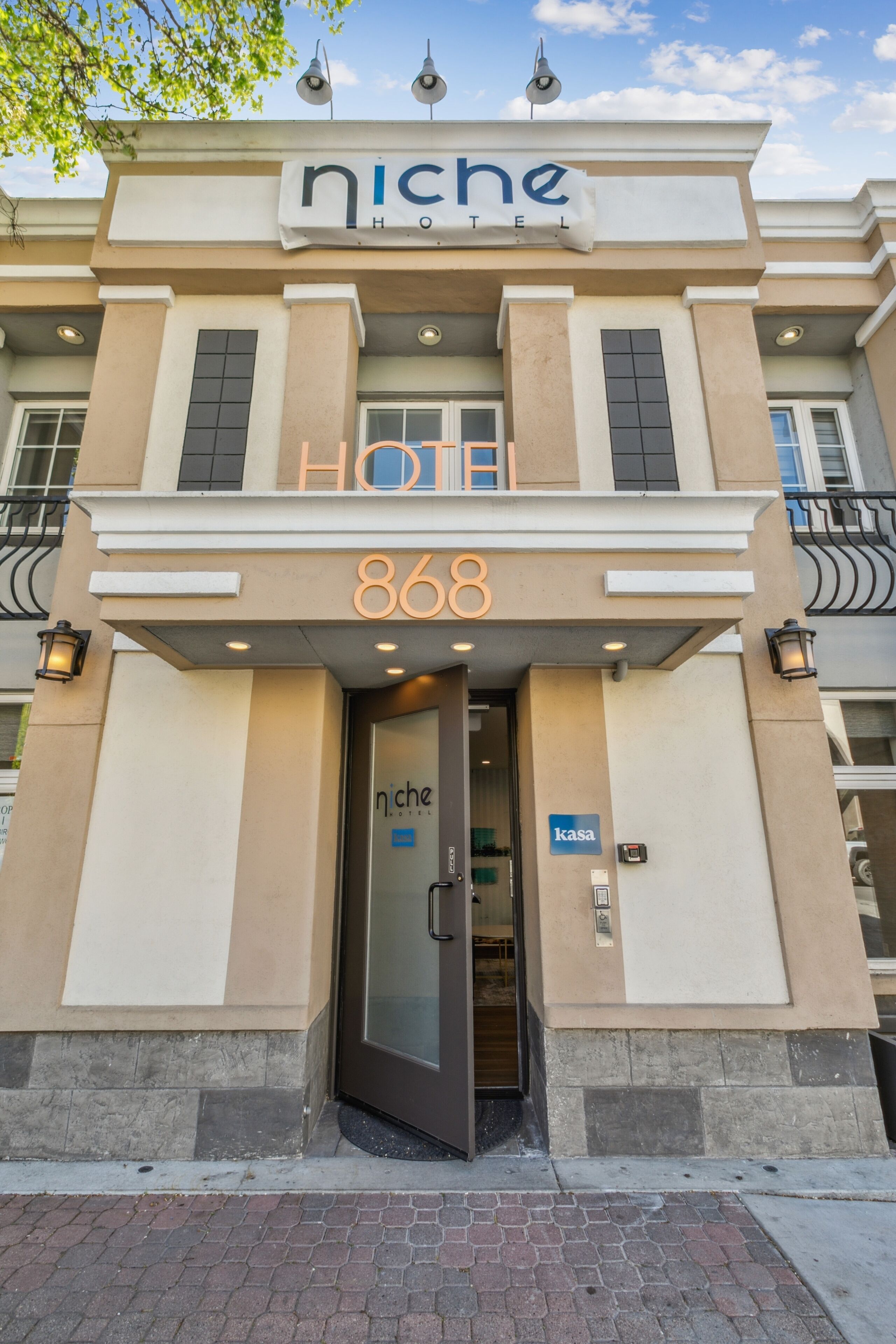 A hotel entrance with a sign reading "niche HOTEL 868" and a "kasa" sign indicating a room type.