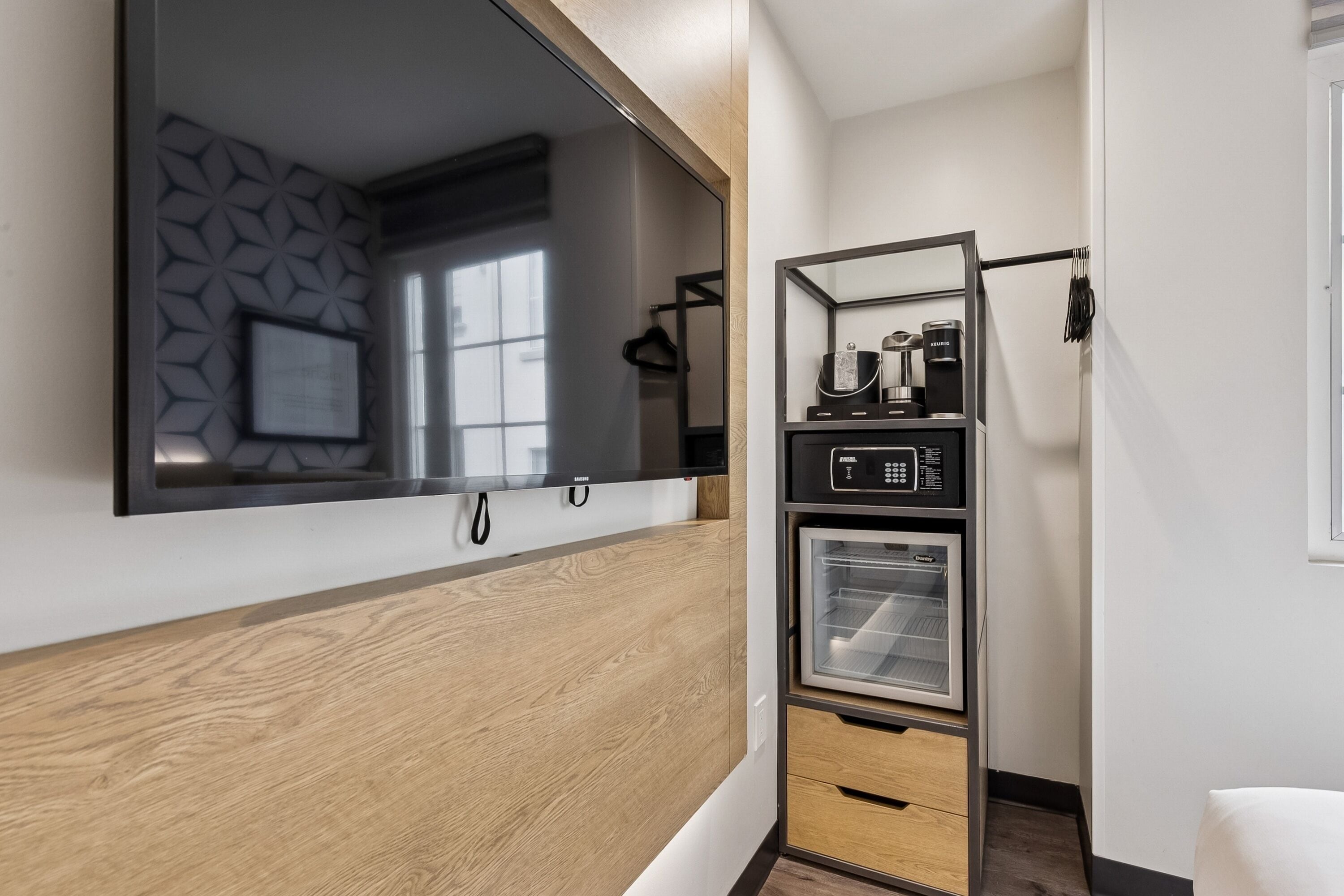 A modern kitchen with a built-in microwave, oven, and coffee maker, and a wooden countertop.