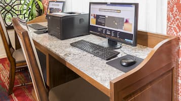 En hotelfacilitet med receptionsdisk, computer, tastatur, mus og printer.