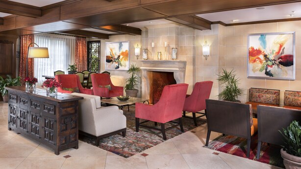 A spacious lobby with a fireplace, seating area, and a large wooden cabinet. - Ayres Hotel Anaheim (Anaheim)