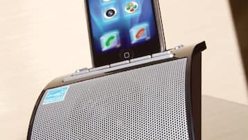 A digital clock with the display reading 10:00, placed on a table.