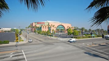 Een Honda Center met een grote, gebogen ingang, omgeven door palmbomen en een heldere lucht.