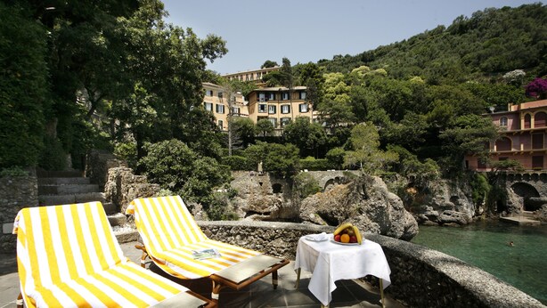 A terrace with two sun loungers, a table with a fruit bowl, and a pool. - Hotel Piccolo Portofino (Portofino)