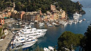 A coastal town with historic buildings, a marina with yachts, and a hilly backdrop. - Hotel Piccolo Portofino (Portofino)