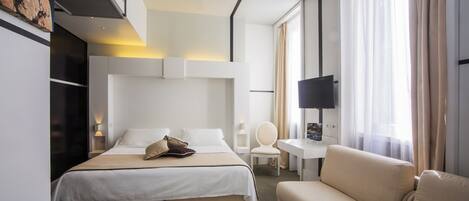 Una habitación de hotel moderna con una cama grande, un sofá, un escritorio y un televisor.