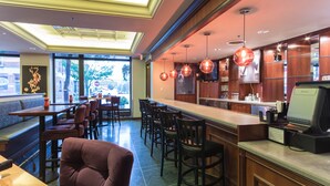 A restaurant with a bar area, seating, and a view of the street. - Hotel Winneshiek (Decorah)