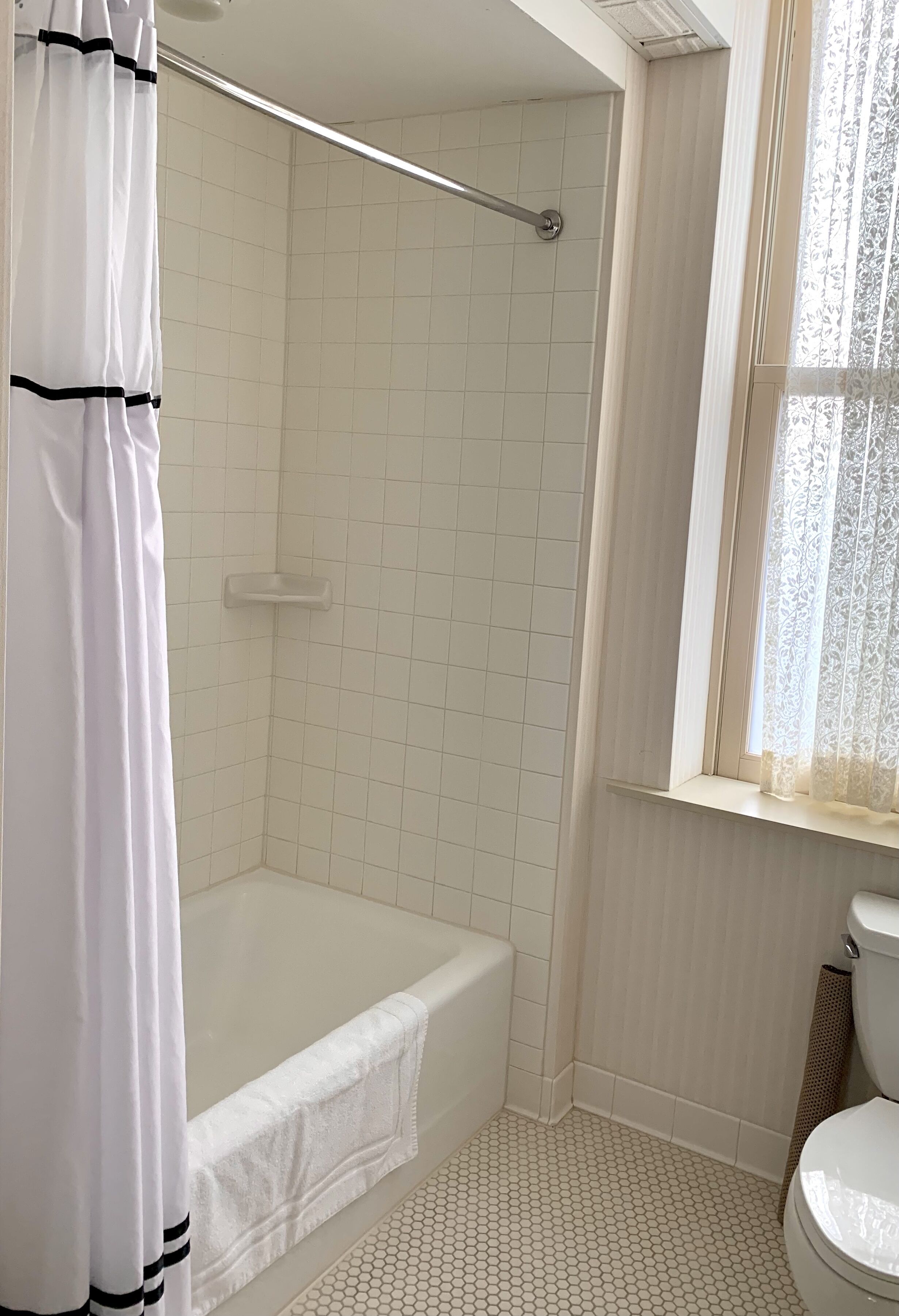 A bathroom with a shower, toilet, and bathtub.
