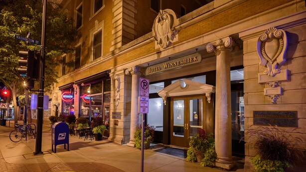 A historic building with a classic architectural style, featuring a prominent entrance with a large door and columns. - Hotel Winneshiek (Decorah)