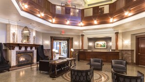 A spacious lobby with a fireplace, seating area, and a reception desk. - Hotel Winneshiek (Decorah)