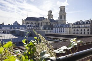 Ein Blick auf ein historisches Gebäude mit einem markanten Turm und einer Kuppel, umgeben von anderen Gebäuden unterschiedlicher Architekturstile.