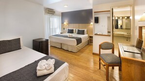 A hotel room with a large bed, a desk with a laptop, a chair, and a mirror. - Hotel Sheltown (Buenos Aires)