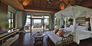 A spacious bedroom with a large bed, a TV, and a balcony with a view of the sea.