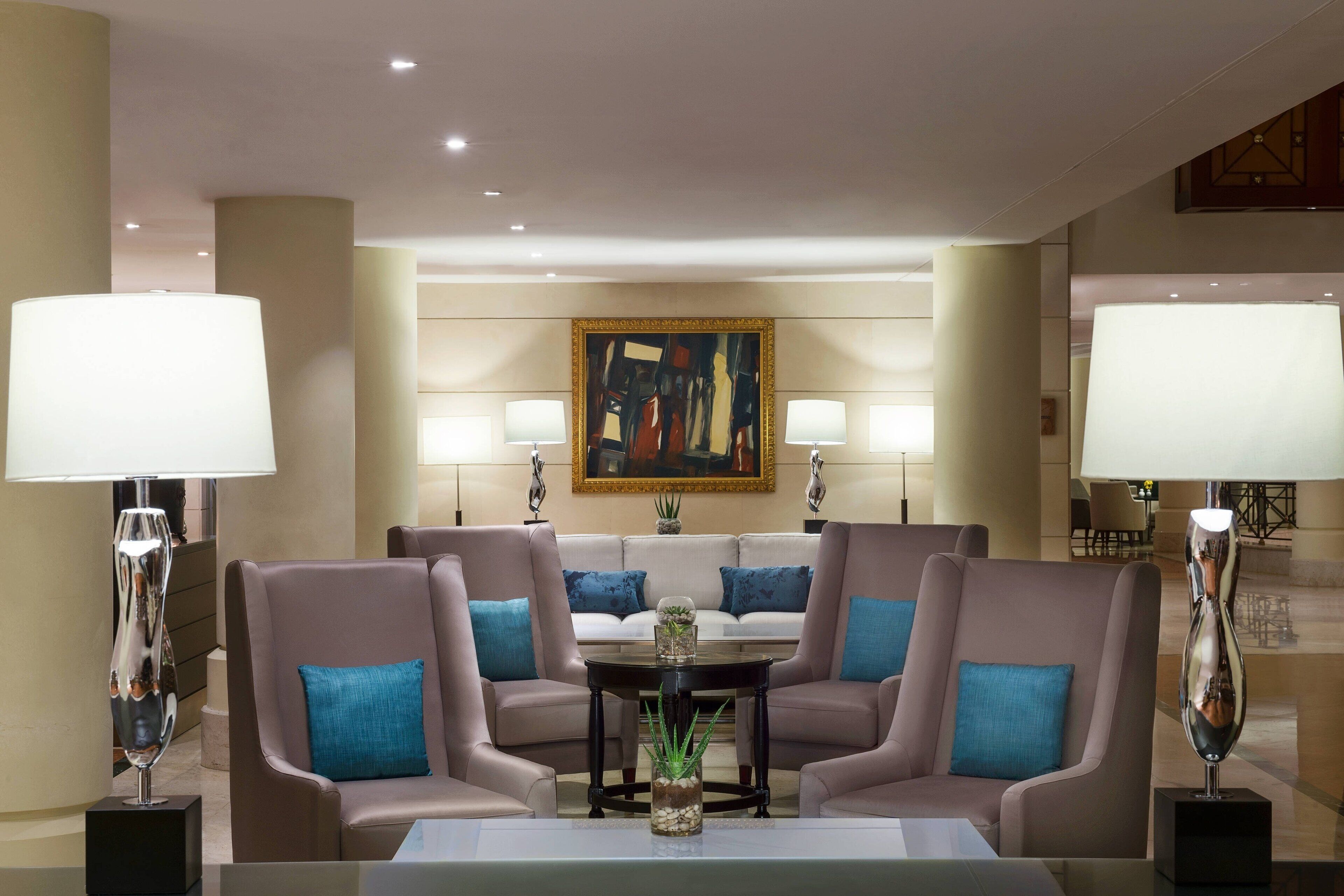 A modern lobby with a sofa set, a coffee table, and two lamps.