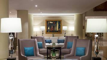 A modern lobby with a sofa set, a coffee table, and two lamps.