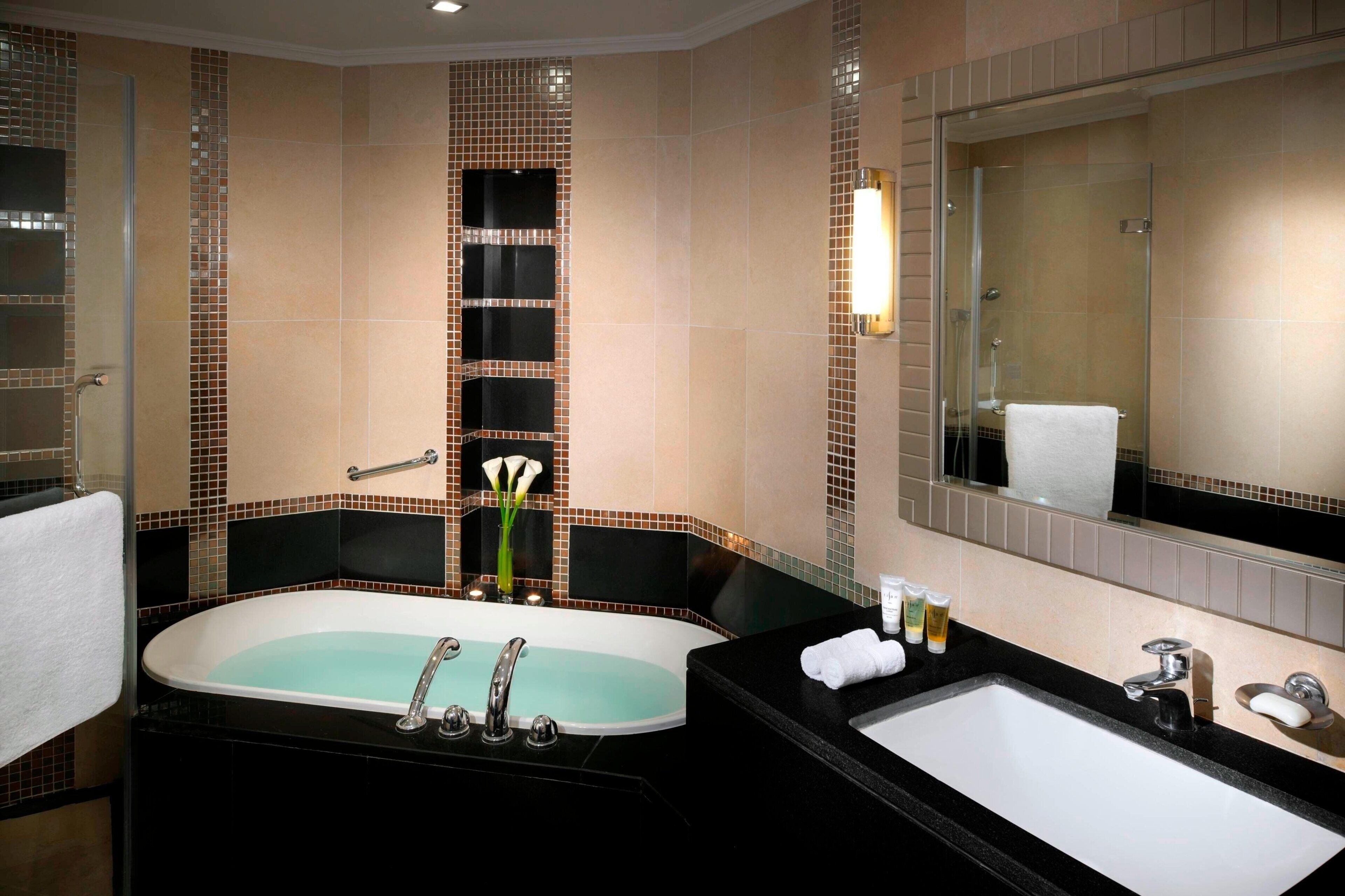Une salle de bain moderne avec une baignoire sur pieds, un meuble-lavabo et un grand miroir.