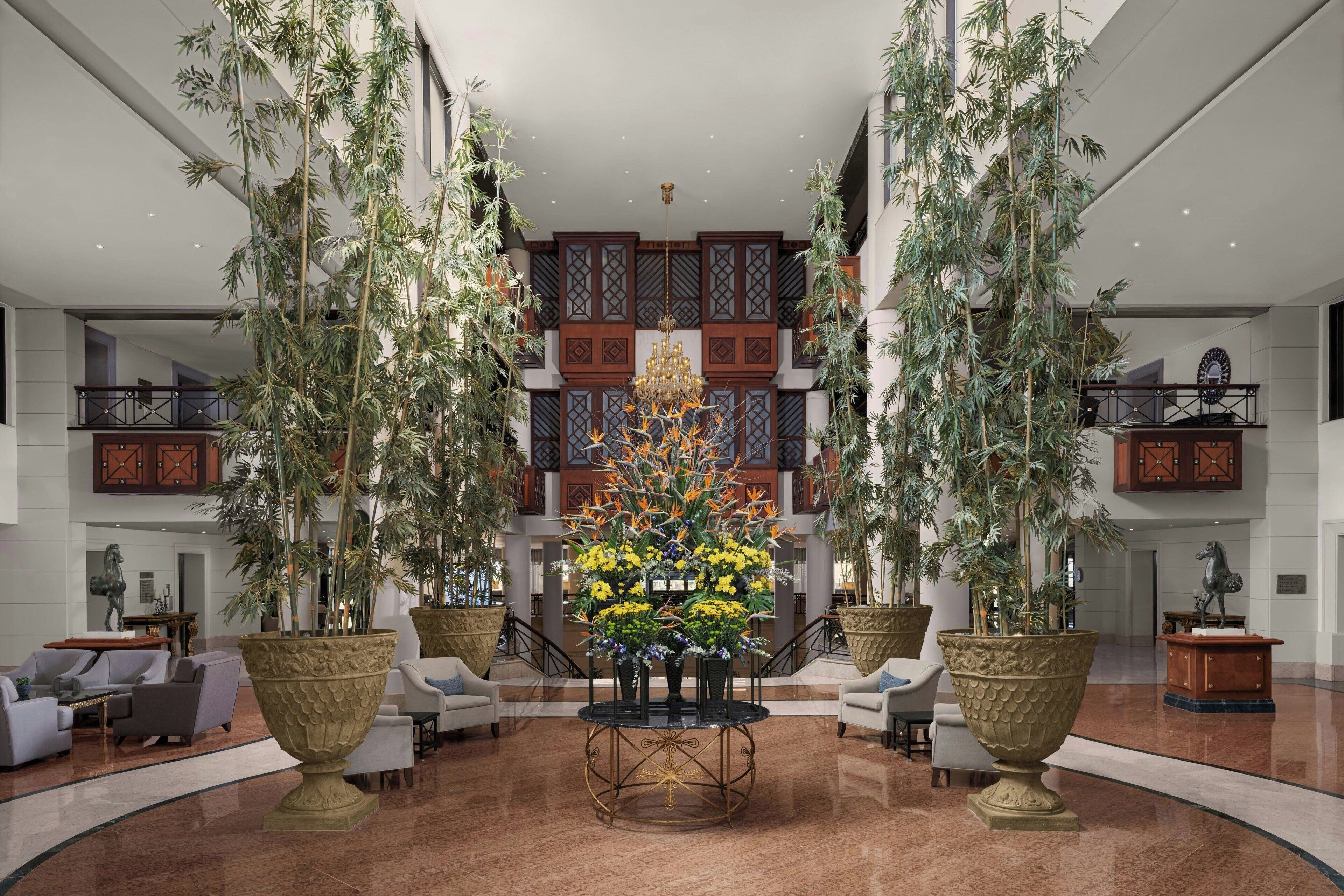 Eine geräumige Lobby mit einer zentralen Blumenkomposition, hohen Decken und traditioneller Einrichtung.