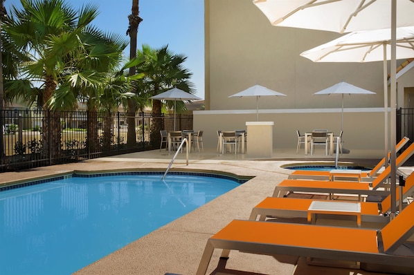 Alberca al aire libre y camastros 