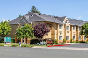 A hotel with a sign reading "Quality Inn & Suites" and a parking lot in front.