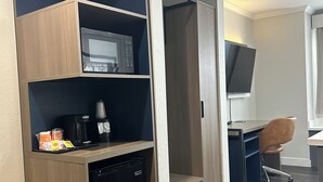 A compact hotel room with a kitchenette, a microwave, a coffee maker, and a TV. - Econo Lodge Inn & Suites Santa Rosa South (Santa Rosa)