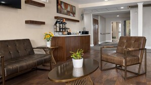 A modern lobby with a sofa, armchair, coffee table, and a small bar area with coffee machines. - Econo Lodge Inn & Suites Santa Rosa South (Santa Rosa)